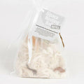 Alpaca Nester Refill: A close-up of a plastic bag containing soft white and brown alpaca wool, ideal for bird nest insulation.