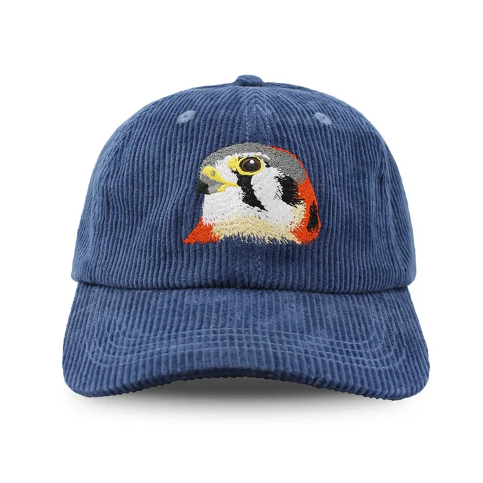 American Kestrel Corduroy Hat, Midnight Spruce, featuring a blue corduroy design with an embroidered kestrel head, adjustable strap, and six-panel crown.