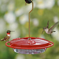Aspects HummZinger Mini hummingbird feeder with wraparound perch, two feeding hummingbirds, suspended by a brass hook against a softly blurred natural background.