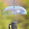 Aspects Weather Dome protecting a bird on a feeder, showcasing its clear plastic design and hanging hooks for easy cleaning and refill.