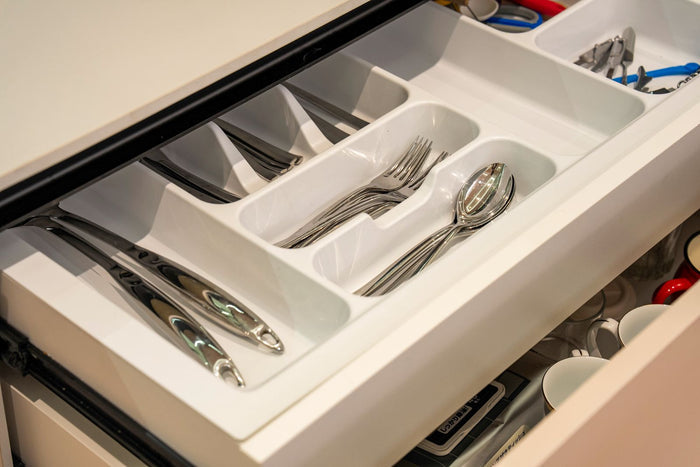 Cutlery drawer organiser holding kitchen utensils