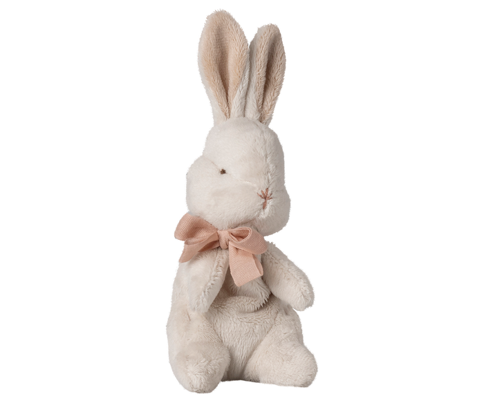 Stuffed rabbit toy with a pink bow on a white background.
