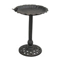 Black metal bird bath on a white background