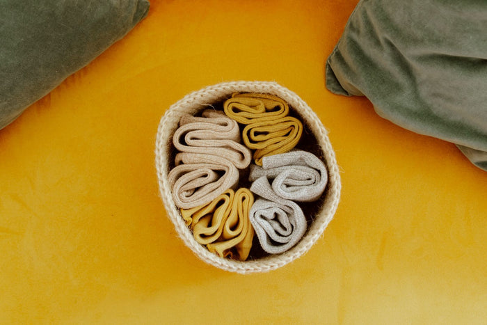 Small round jute rope basket holding folded cloths