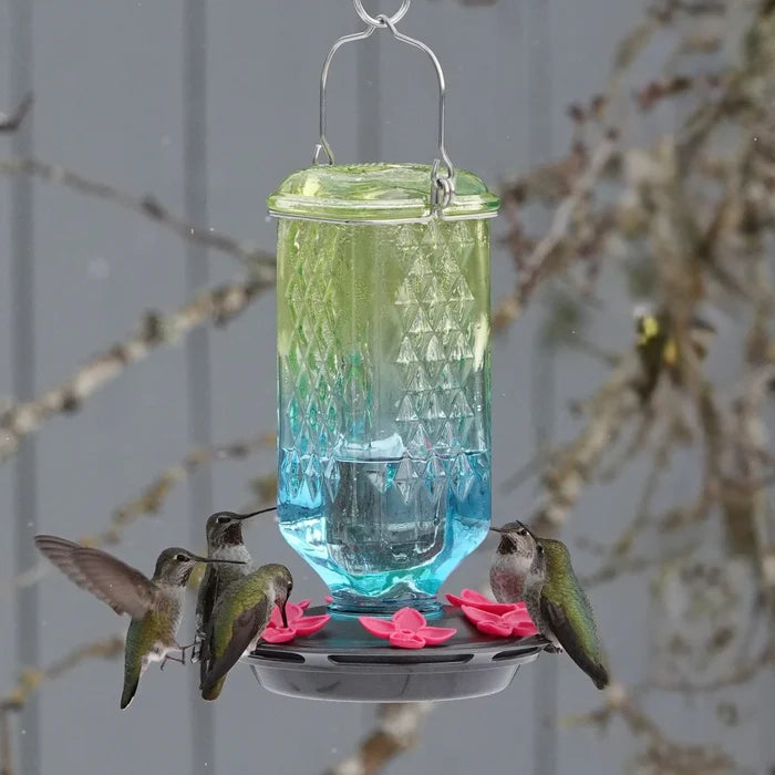 Seafoam ombre antique glass hummingbird feeder attracting hummingbirds, showcasing the decorative column design and multiple feeding stations.