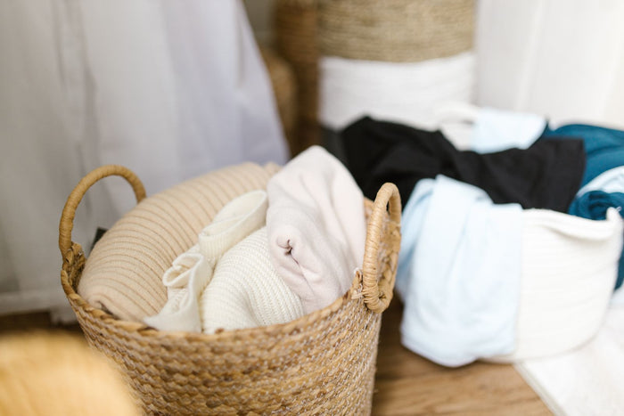 Seagrass basket holding folded linen on a bedroom floor