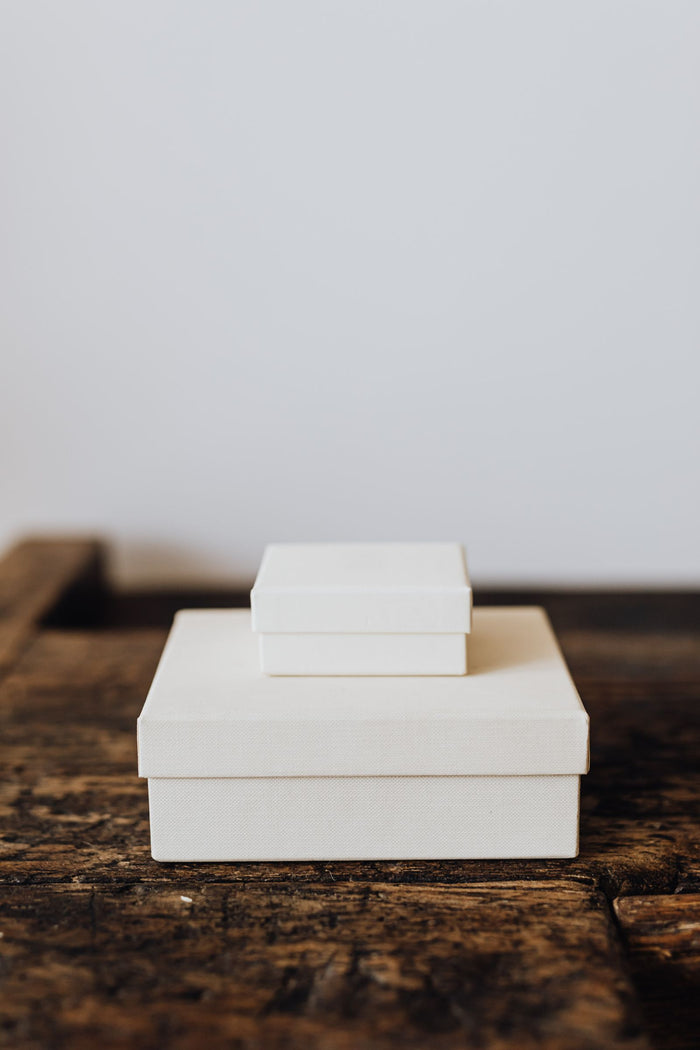 White lidded boxes on a wooden surface