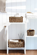 White shelving with woven baskets and folded towels