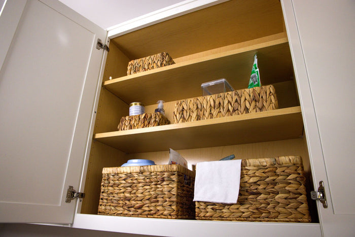 Water hyacinth baskets stacked inside a kitchen cupboard