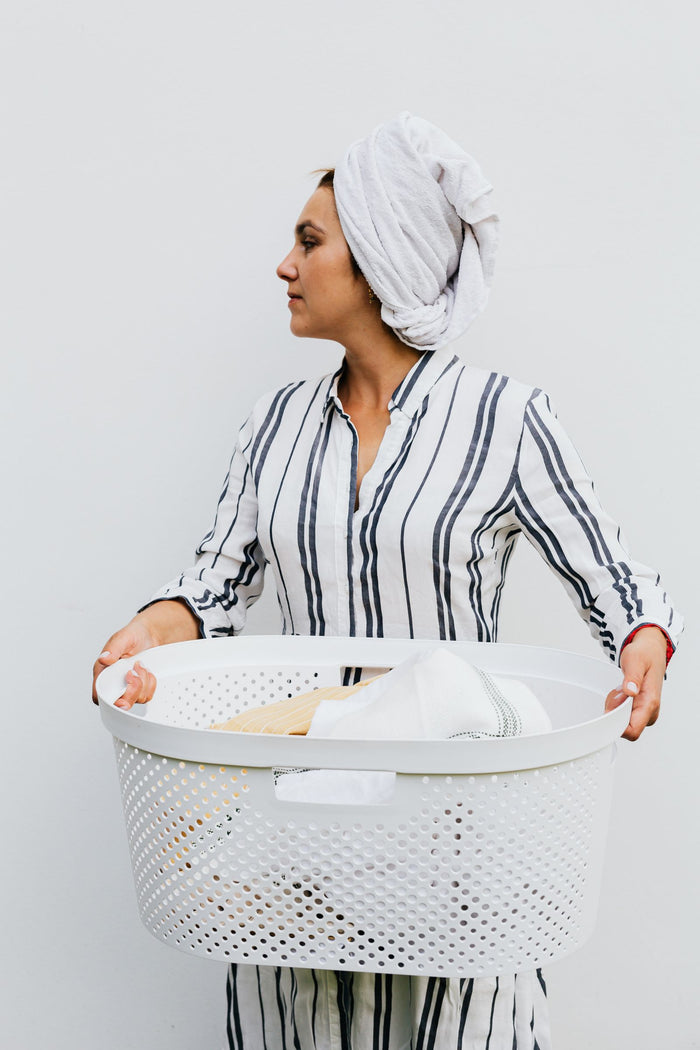 White mesh laundry basket held in both hands